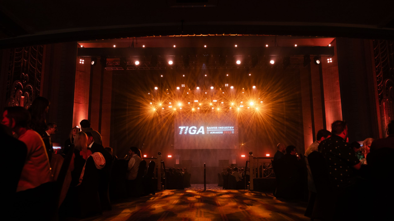 The TIGA Awards. A lit stage as a crown of people wait to hear who will be crowned winners.