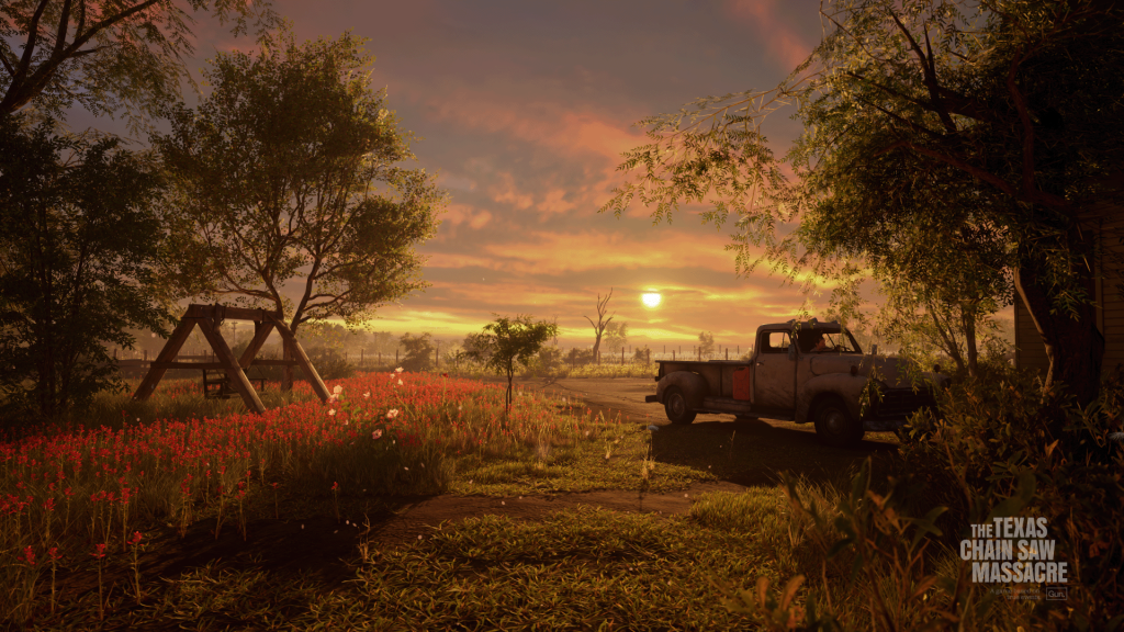 A still from The Texas Chain Saw Massacre. The exterior of the family house at sunset - a swing and a truck frame a beautiful field of flowers.